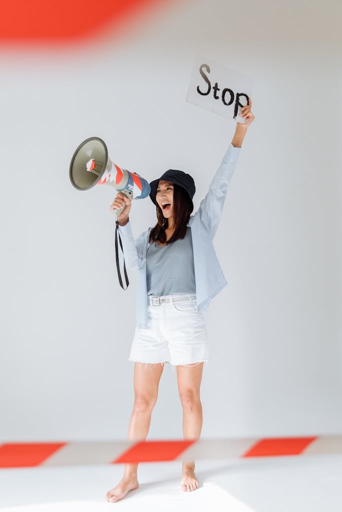 A Woman Shouting on a Megaphone while Holding a Sign